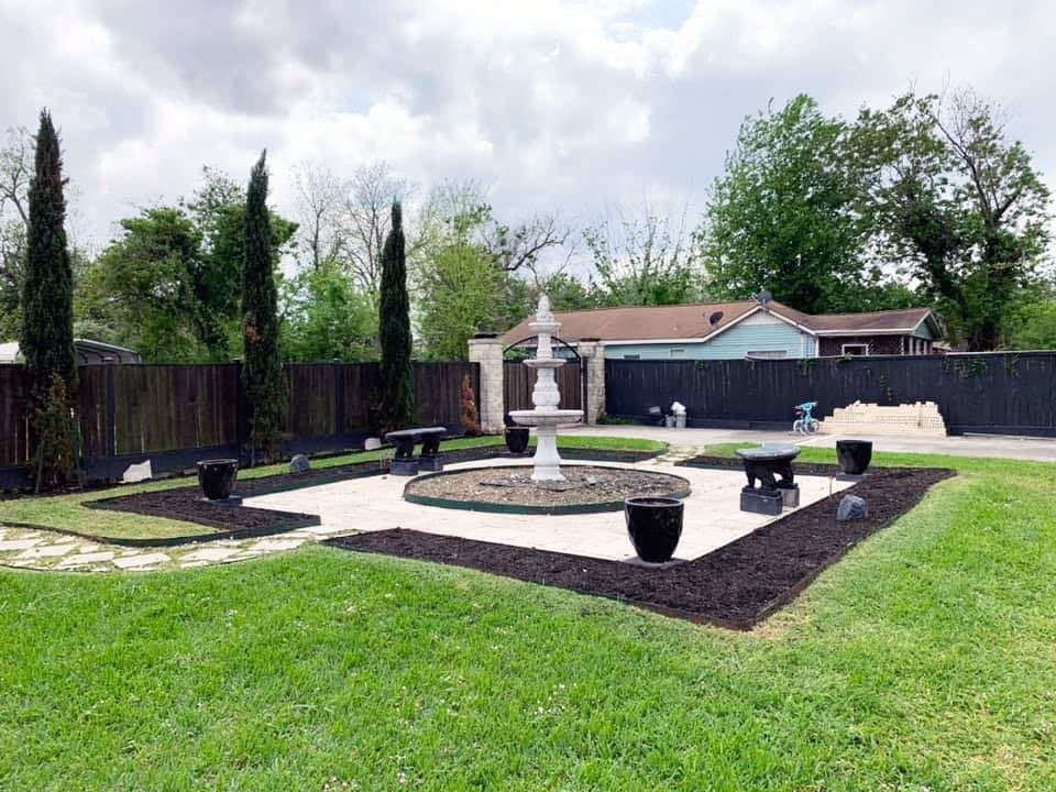Illuminated paver courtyard and landscaping at a Houston property in the evening