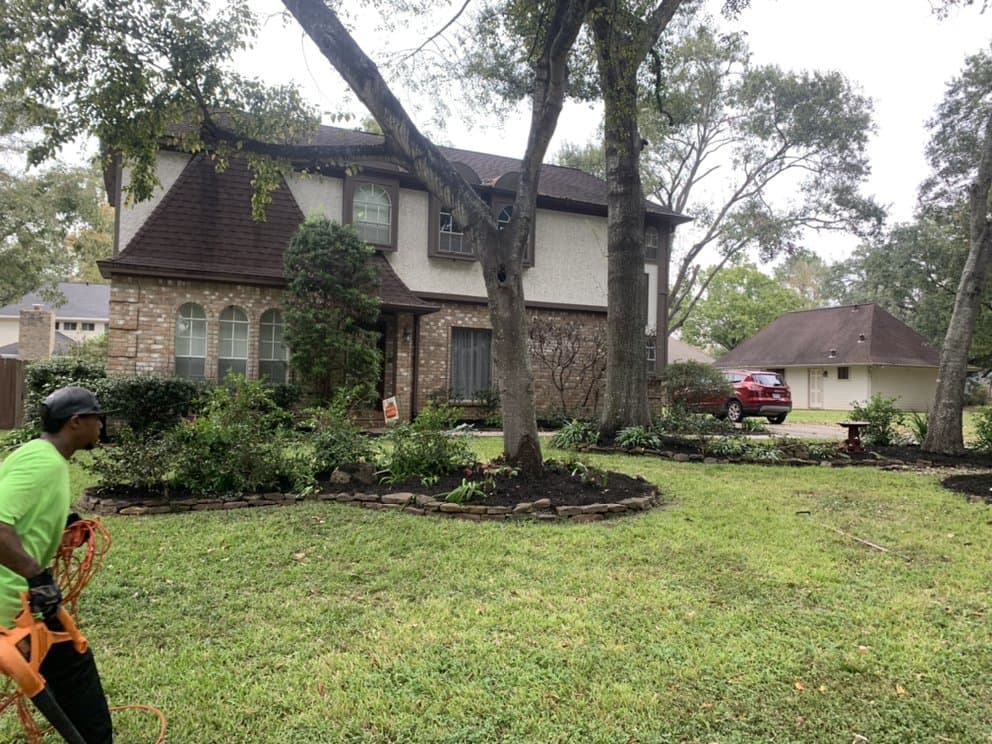 Seventree crew member edging a curved flower bed at a Houston home