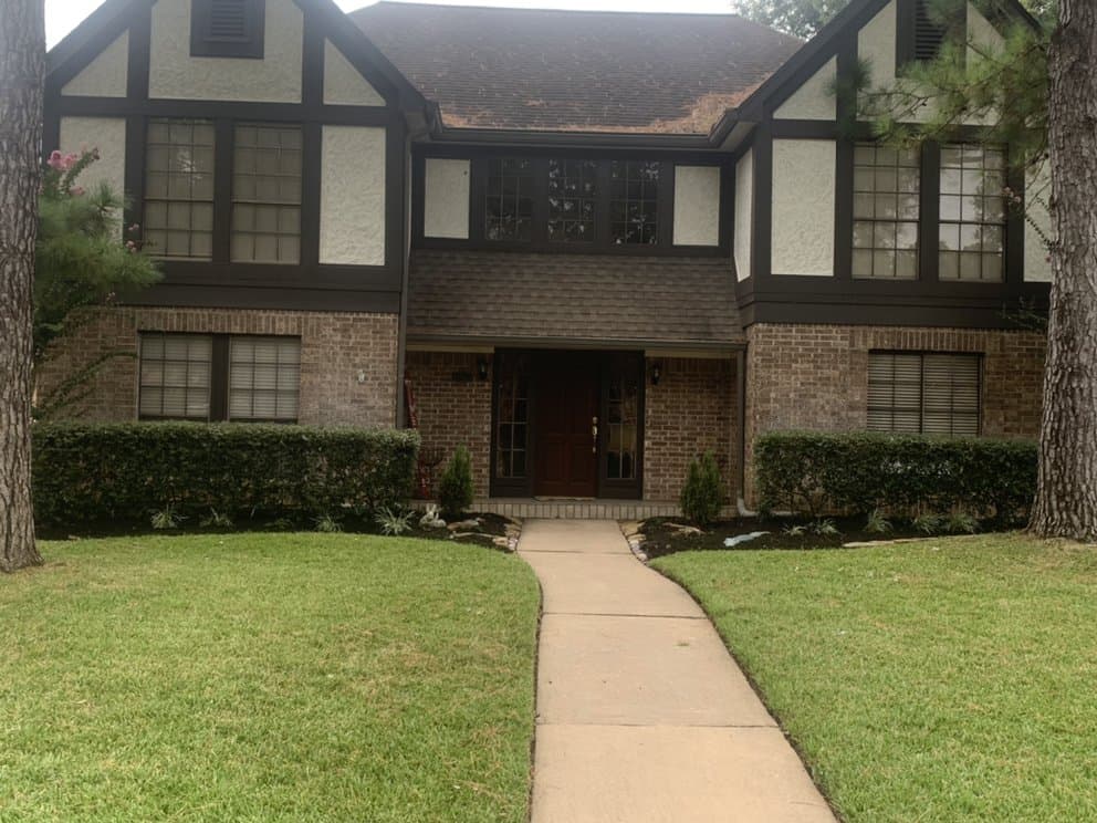 Aerated, healthy lawn in front of a two-story Houston brick home