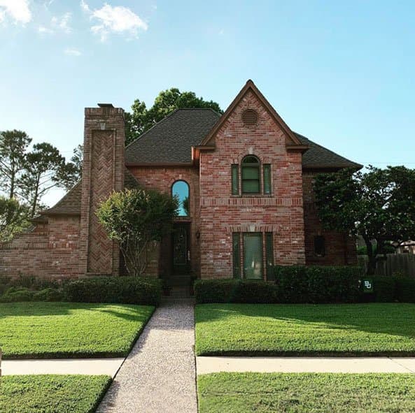 Healthy, weed-free green lawn at a Houston brick home after fertilization
