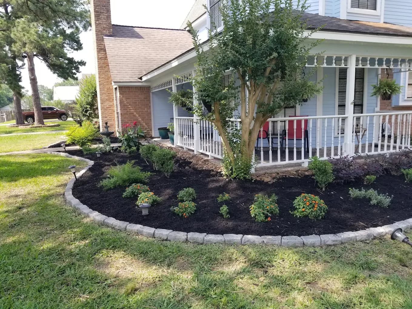 Fresh dark mulch bed with a clean edge and new plantings at a Houston home