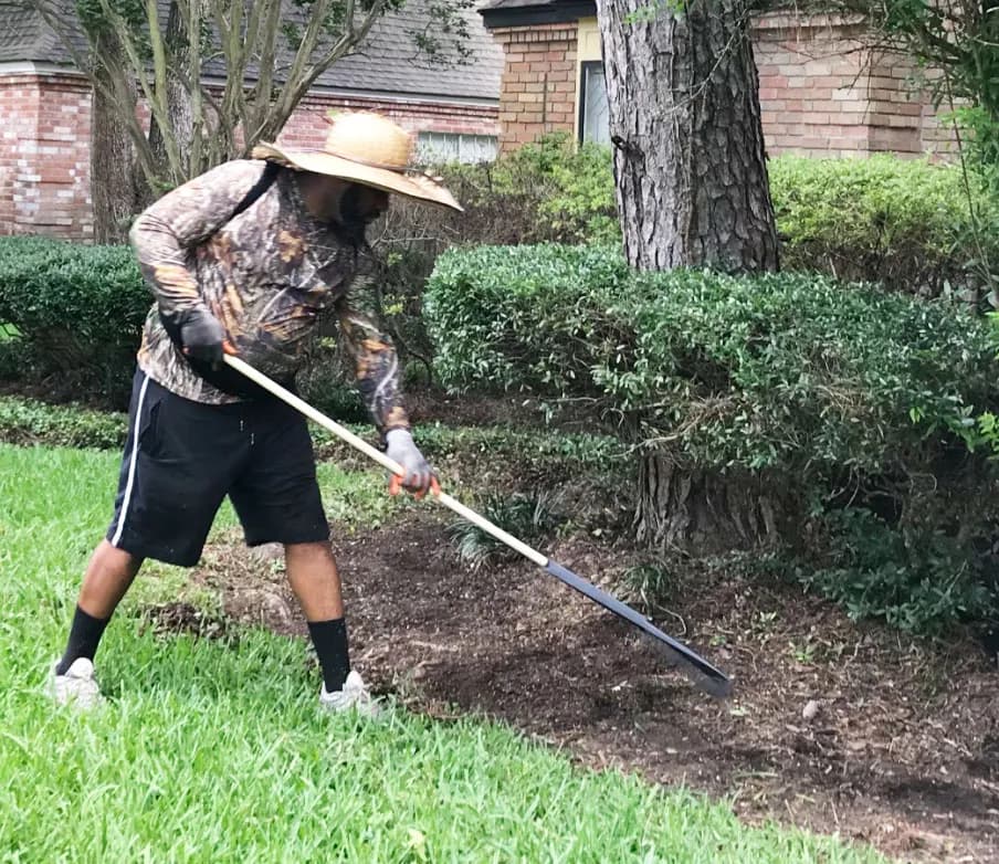 Seventree crew member raking and clearing leaves during a Houston yard cleanup